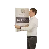 a man is holding a sign that says te koop on it