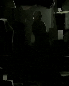 a silhouette of a man in a dark room with his eyes closed