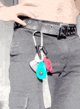 a person without a shirt is wearing a black belt with holes and keys hanging from it