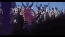 a crowd of people with their arms in the air including a man wearing a shirt that says ' a '