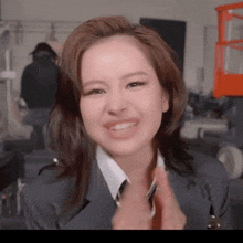 a woman in a suit and tie is smiling