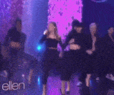 a group of women are dancing on a stage with the word ellen in the corner