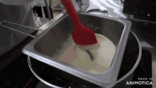 a person is mixing something in a pan that says made in animatica on the bottom