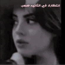 a close up of a woman 's face with arabic writing on the bottom