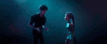 a man and woman are standing next to each other in a dark room .