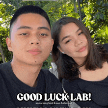 a man and a woman are posing for a picture with a caption that reads good luck lab