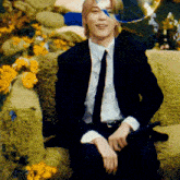 a man in a suit and tie is sitting on a green couch