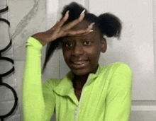 a girl in a neon green jacket is making a funny face .