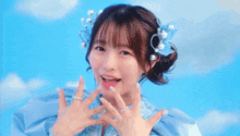 a girl wearing a blue dress and pearls in her hair smiles
