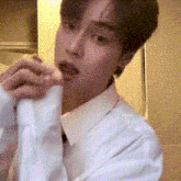 a man in a white shirt and tie is holding a piece of paper in his hands .