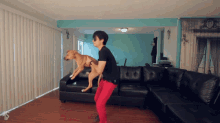a man in red pants is holding a dog on his shoulders
