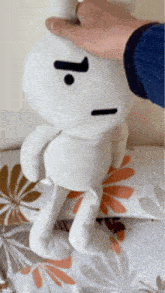a person is petting a stuffed animal that has a j on its face