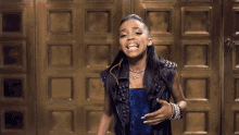 a woman wearing a leather vest and a blue dress is laughing
