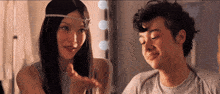 a woman wearing a headband talks to a man