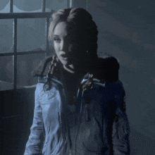 a woman wearing a blue jacket with the word first on the back