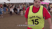 a woman is wearing a yellow vest that says papa fes 15