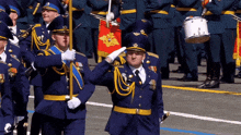a man in a military uniform salutes in front of a drum