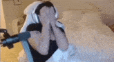 a man wearing headphones is sitting on a bed .