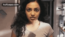 a woman is wearing a white t-shirt with a stain on it .