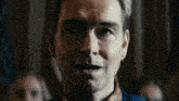 a close up of a man 's face with a crowd of people in the background .