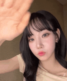 a close up of a woman 's face with her hand up .