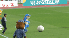 a group of mascots are playing soccer on a field with a sign that says ' a ' on it