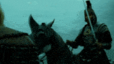 a man in armor is riding a horse with a spear in his hand