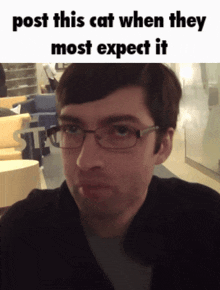 a man wearing glasses looks at the camera with a caption that says post this cat when they most expect it
