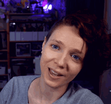 a woman with blue eyes and a nose ring is smiling