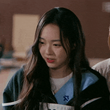 a girl wearing a jacket with the letter s on the collar