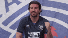 a man wearing a blue shirt that says unibet on it