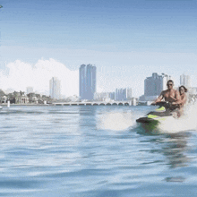 a man and a woman ride a jet ski in the water