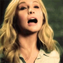 a close up of a blonde woman 's face with her mouth open