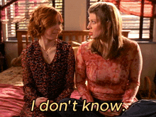 two women sitting on a bed with the words i don 't know written on the bottom