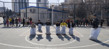 a group of kids are playing a game on a basketball court with a bag that says ' blue ' on it