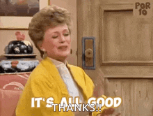 a woman in a yellow jacket is standing in front of a door and saying `` it 's all good thanks ! ''