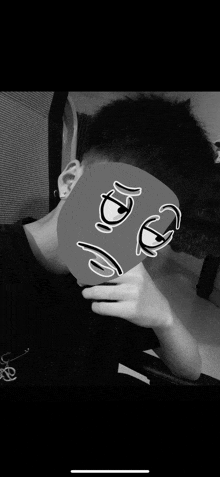 a black and white photo of a person wearing a mask with a sad face on it .