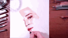 a person is drawing a woman 's face with a brush