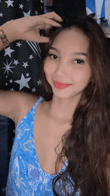 a woman wearing a blue tank top with a watch on her wrist