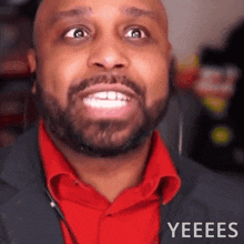 a man with a beard wearing a red shirt is making a funny face and the word yeees is on the bottom right