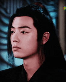 a close up of a young man with long hair