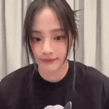 a close up of a girl wearing a black t-shirt and smiling .
