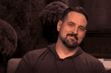a man covering his mouth with his hand while sitting on a couch