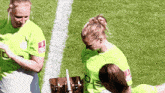 a group of female soccer players are standing on a field