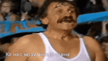 a man with a mustache wearing a white tank top says ko has mp3i nek je gova