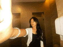 a woman taking a picture of herself in a bathroom mirror
