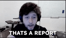 a man wearing headphones says that 's a report in front of a white board
