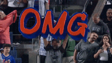 a fan holds up a sign that says " omg "