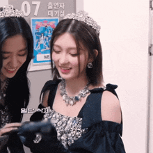 a woman wearing a tiara stands next to another woman