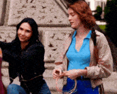 two women are standing next to each other with a tnt logo in the background
